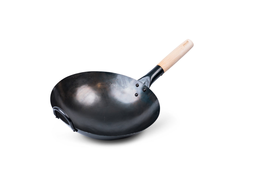 Schräge Ansicht des traditionell handgehämmerten voreingebrannten pasoli Woks mit rundem Boden auf weißem Hintergrund.