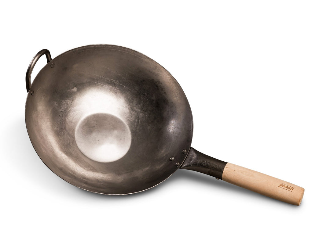 Vista oblicua del wok pasoli tradicionalmente martillado a mano con fondo plano.